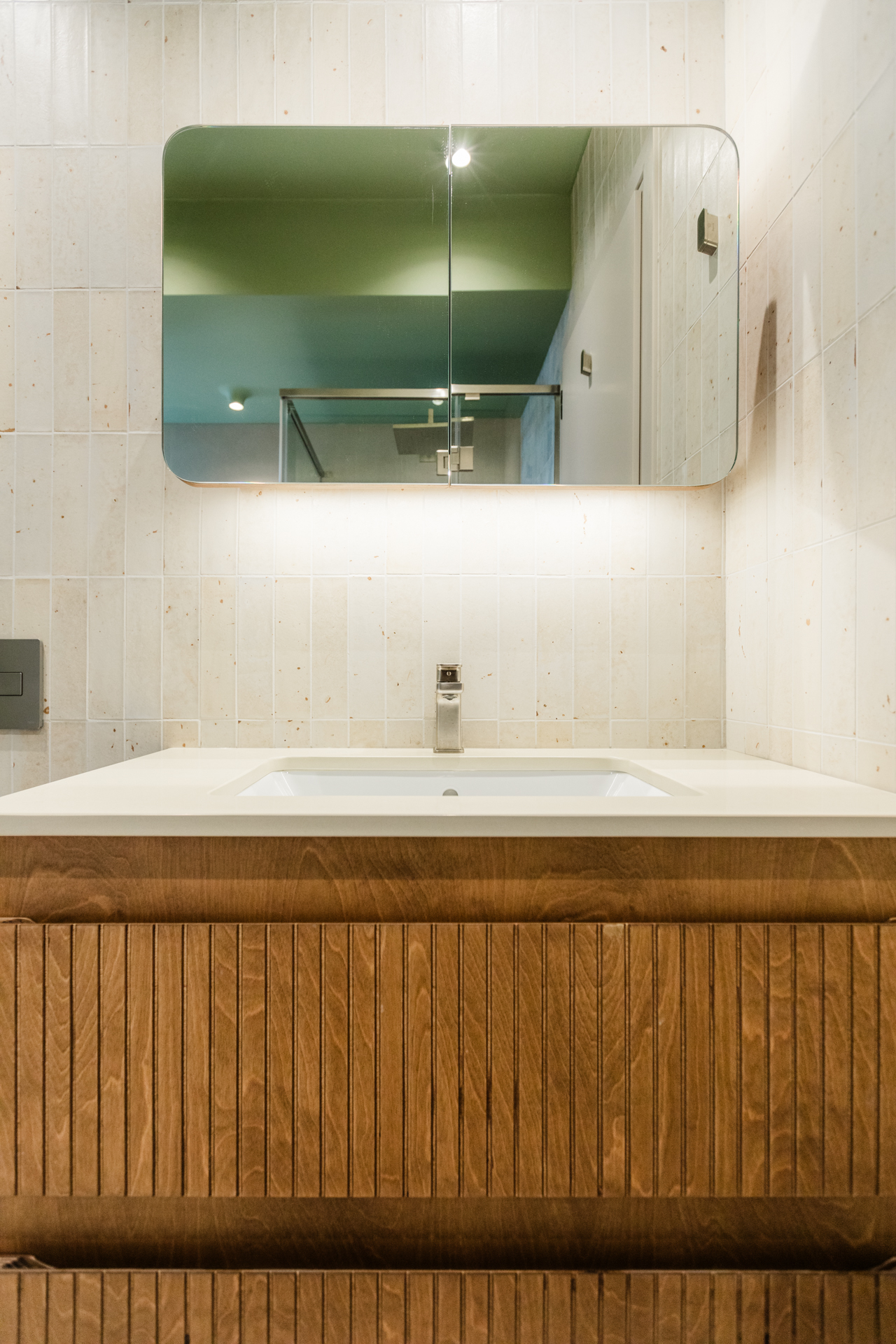 Μοντέρνο μπάνιο με ντουζιέρα και μπανιέρα Πράσινα εξαγωνικά πλακάκια μπάνιου Ξύλινο έπιπλο μπάνιου με fluted λεπτομέρειες Μπλε πλακάκια τοίχου μπάνιου Εντοιχισμένο καζανάκι και κρεμαστή λεκάνη Μοντέρνα καμπίνα ντους με διάφανο κρύσταλλο