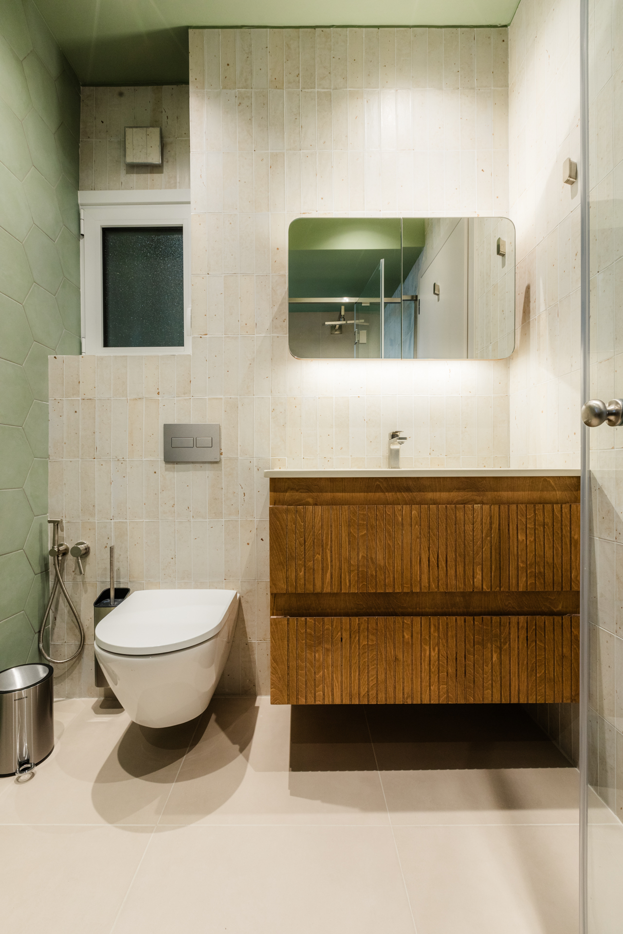 Μοντέρνο μπάνιο με ντουζιέρα και μπανιέρα Πράσινα εξαγωνικά πλακάκια μπάνιου Ξύλινο έπιπλο μπάνιου με fluted λεπτομέρειες Μπλε πλακάκια τοίχου μπάνιου Εντοιχισμένο καζανάκι και κρεμαστή λεκάνη Μοντέρνα καμπίνα ντους με διάφανο κρύσταλλο