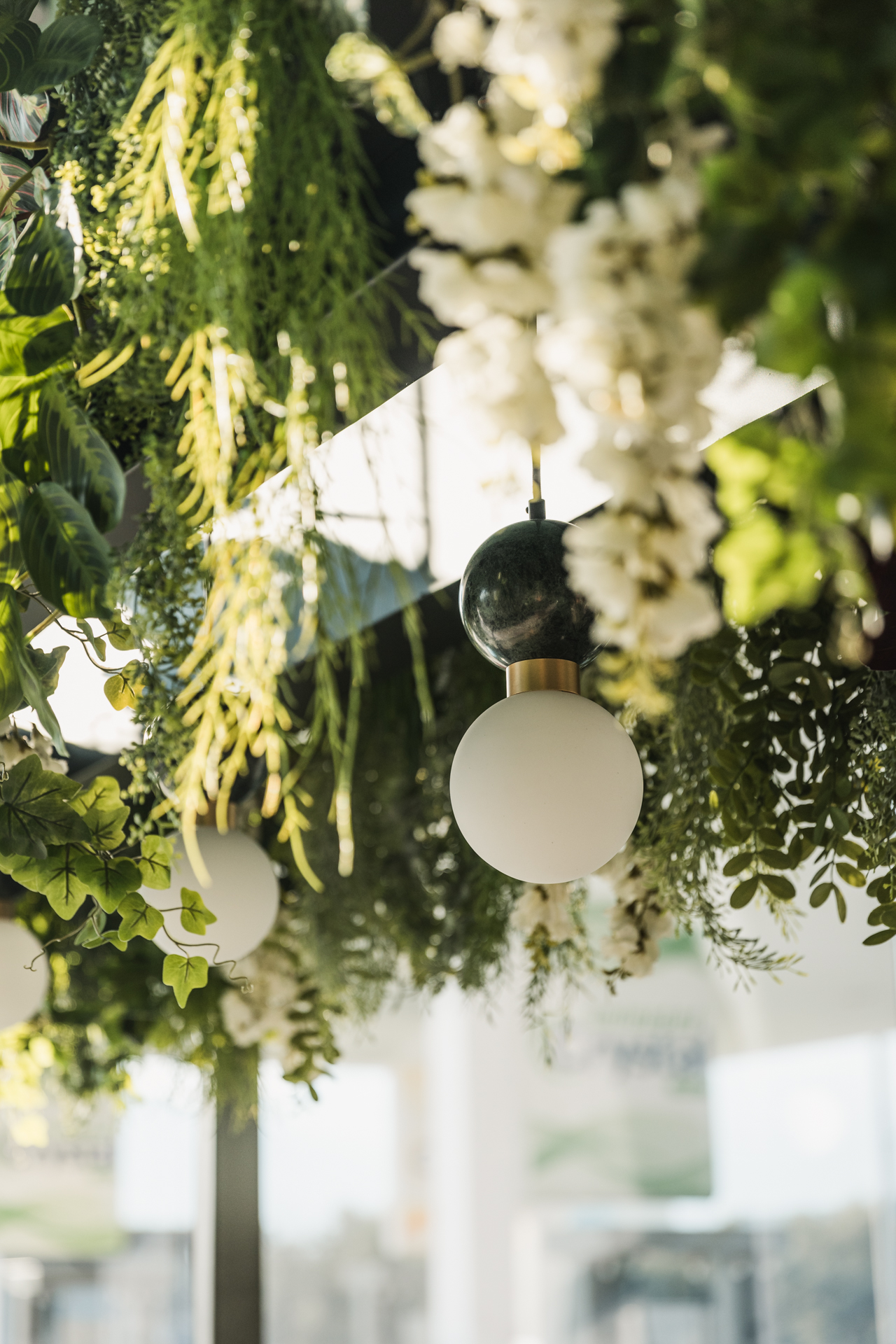 Εσωτερικός χώρος μοντέρνου καφέ με γκρι καθίσματα, ξύλινους τοίχους και πράσινη οροφή.