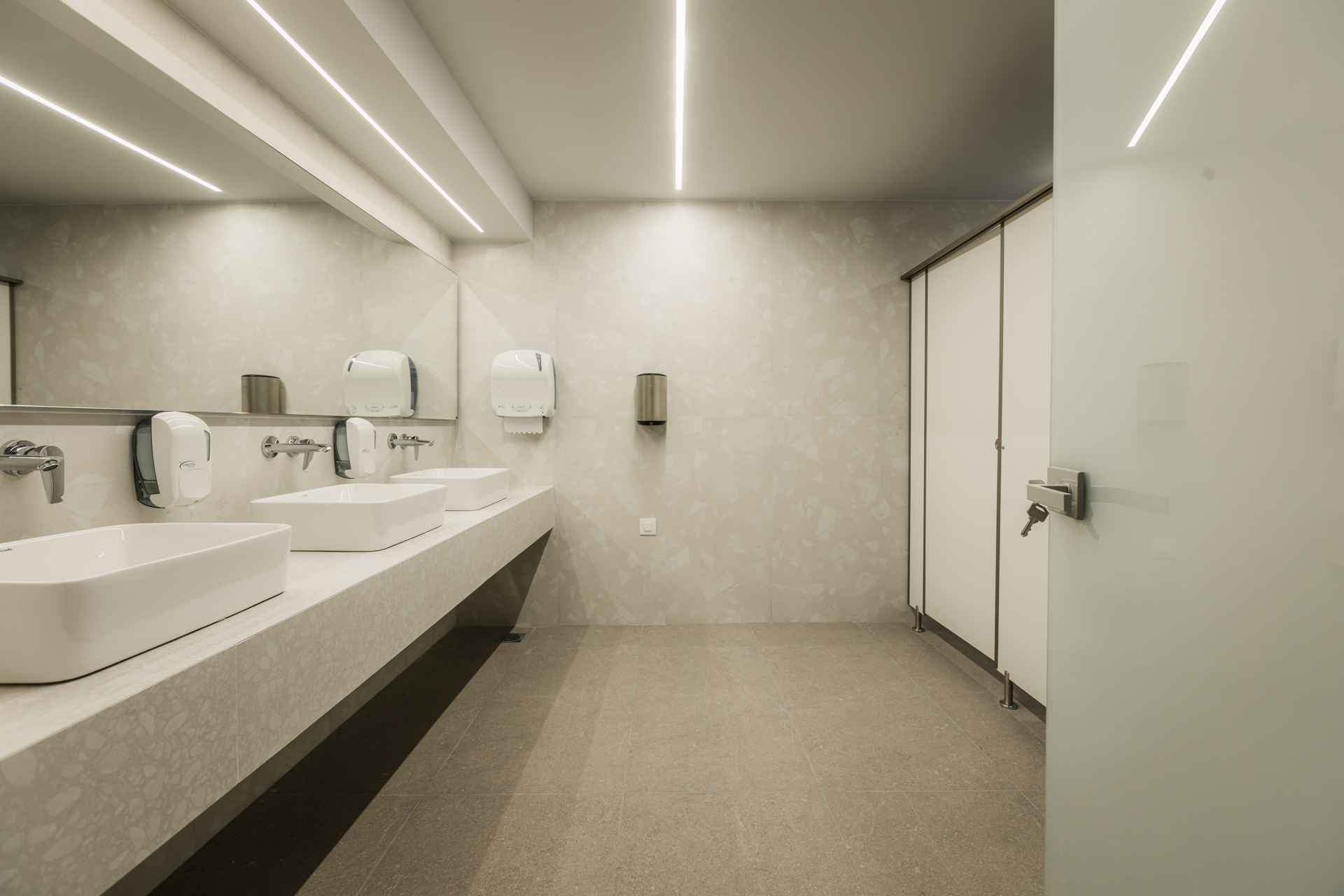 Εσωτερικός χώρος μοντέρνου καφέ με γκρι καθίσματα, ξύλινους τοίχους και πράσινη οροφή.