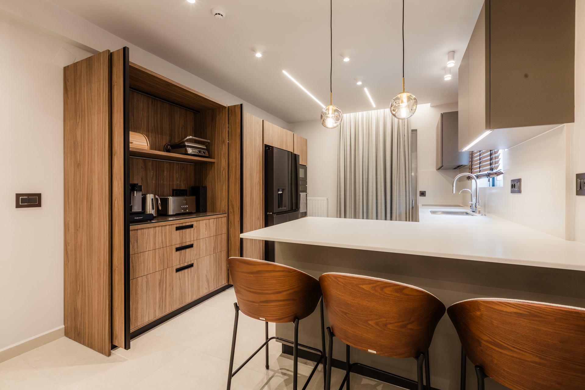 Μοντέρνα κουζίνα με νησίδα Minimal σχεδιασμός κουζίνας Εντοιχισμένες συσκευές κουζίνας Κρεμαστά φωτιστικά κουζίνας (Glass pendants) Ξύλινα σκαμπό μπαρ