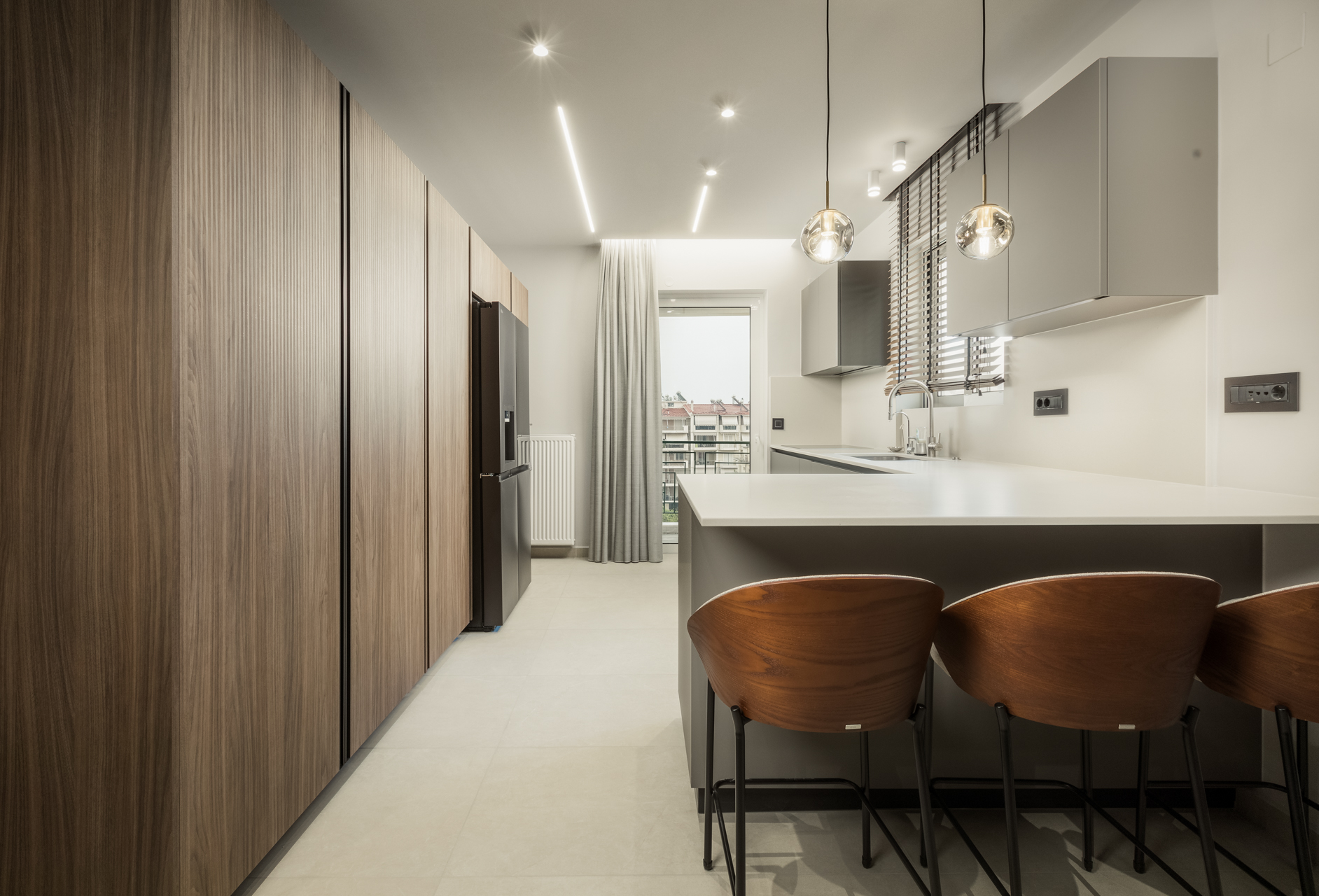 Μοντέρνα κουζίνα με νησίδα Minimal σχεδιασμός κουζίνας Εντοιχισμένες συσκευές κουζίνας Κρεμαστά φωτιστικά κουζίνας (Glass pendants) Ξύλινα σκαμπό μπαρ